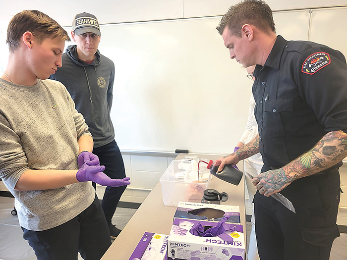 <b>From left are, </b>Kyrylo Dehtiar learning about wound packing from Nelson Bate, firefighter for the City of Edmonton. Bate is one of the few firefighters heading to Ukraine to teach doctors and first responders in Ukraine about Tactical Combat Casualty Care (TCCC).<br />
